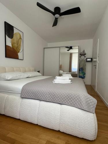a bedroom with a bed with a ceiling fan at Apartments Elin in Omiš
