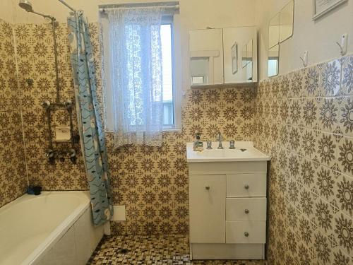 Un baño con bañera, lavabo y ducha. en Affordable Queen Room in Earlwood - EW5, en Sídney
