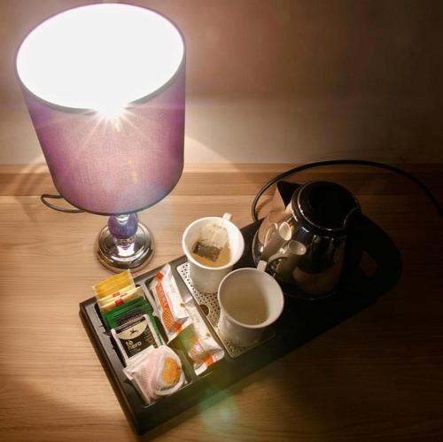 a table with a lamp and a tea kettle and cups at Locanda Papà Nenè in Osnago