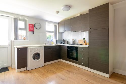 a kitchen with a washing machine and a washer at Spacious Ground Floor 2 Bed Apartment Free Parking Pet Friendly in Loughborough