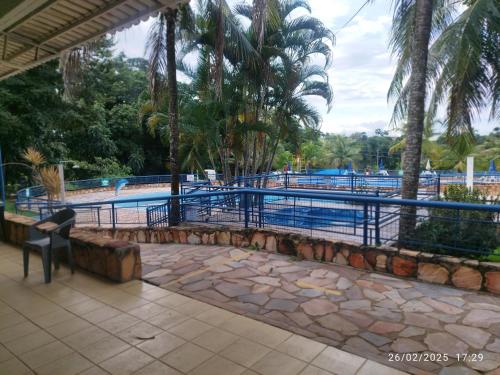 una vista de una piscina con palmeras en casa temporada caldas nova com 3 quartos Condomínio Village muito área verde,piscinas, sauna, en Caldas Novas
