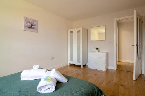 a bedroom with a bed with two towels on it at Large Ground Floor Pet Friendly 2 Bedroom Apartment with FREE Parking in Loughborough