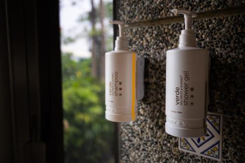 two white bottles are hanging on a wall at Jungle City Motel in Chiayi City