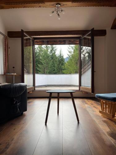 a living room with a table in front of a window at Ferienhaus Wimmer in Faistenau