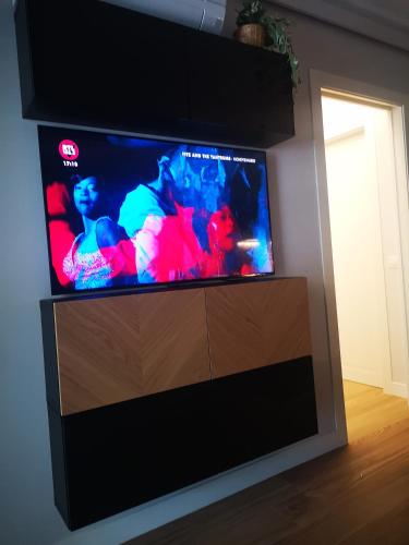 a flat screen tv sitting on top of a entertainment center at HOLIDAYS HOMES ROME GOLF Appartamenti Marco Simone AeB in Marco Simone