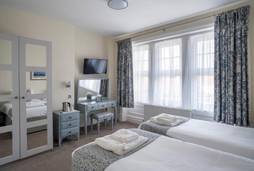 a hotel room with two beds and a window at Grand Hotel Swanage in Swanage