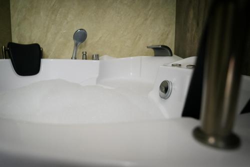 a white sink in a bathroom with aaucet at Tamyoz Aqama for Serviced Apartments in Hail