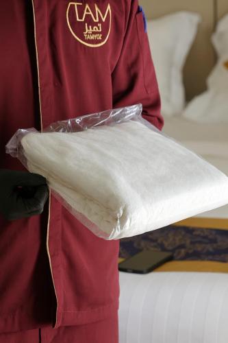 a person holding a piece of dough in a bag at Tamyoz Aqama for Serviced Apartments in Hail