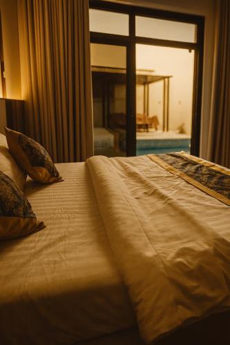 a bed in a hotel room with a large window at Tamyoz Aqama for Serviced Apartments in Hail