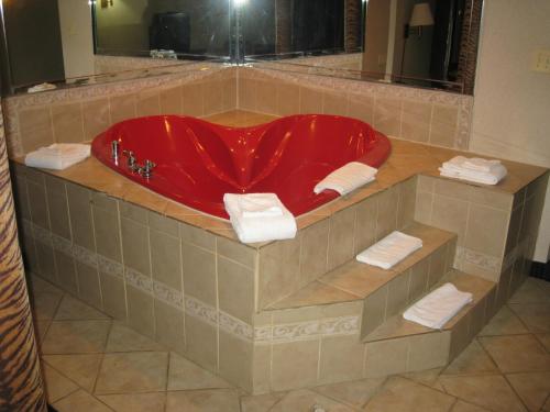 y baño con bañera roja y toallas. en Budget Inn Temple Hills, en Temple Hills