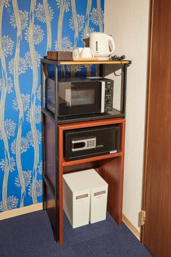 a microwave on a stand in a room at Kyoto Gojo T 京都五条ツイン in Kyoto