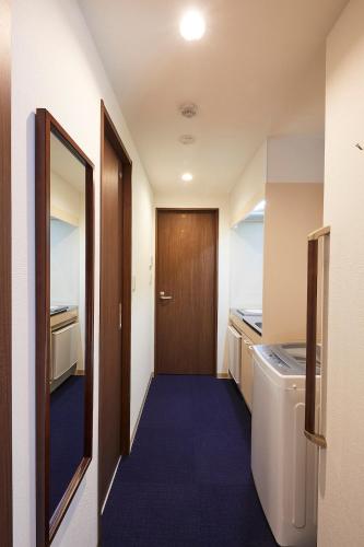 a small room with a door and a washing machine at Kyoto Gojo T 京都五条ツイン in Kyoto