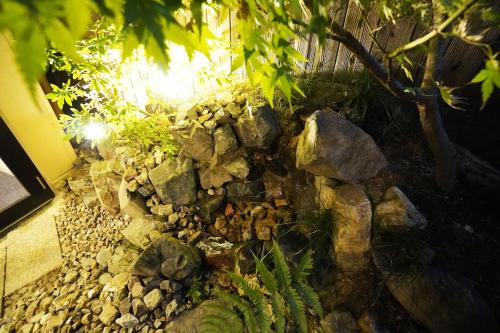 a garden with rocks and trees and plants at Kyoto Gojo T 京都五条ツイン in Kyoto