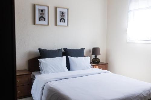 a bedroom with a bed with white sheets and a window at Casa Natura 