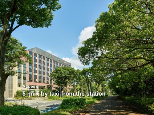 a street with a building and trees with the words minivan by taxi from at Mitsui Garden Hotel Kashiwa-no-ha Park Side - Chiba in Kashiwa