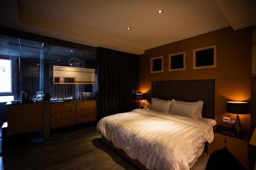 a bedroom with a bed and a desk and a window at Jungle City Motel in Chiayi City