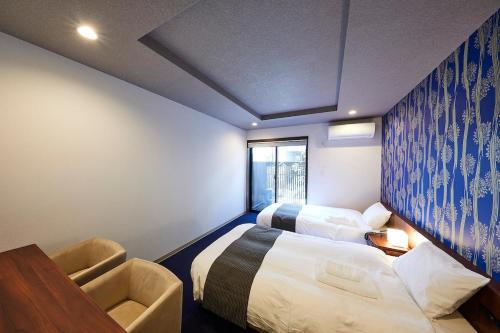 a hotel room with two beds and a desk at Kyoto Gojo T 京都五条ツイン in Kyoto