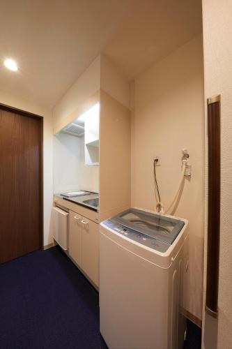 a small kitchen with a washing machine and a sink at Kyoto Gojo T 京都五条ツイン in Kyoto
