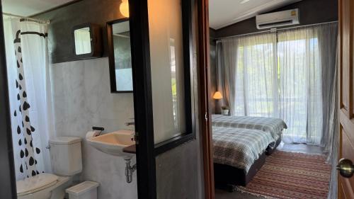 a bathroom with a bed and a sink and a toilet at Baan Chiang Residence & Resort- Hua Hin in Ban Pak Ngam