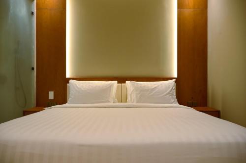 a large white bed with two pillows on it at Hygge Hotel and Villas Seminyak in Seminyak