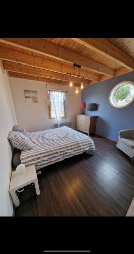 a large bedroom with a large bed and a window at Belle Maison bois avec piscine proche de la plage in Landéda