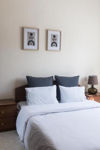 a bedroom with a large bed with two pictures on the wall at Casa Natura in Kilkis