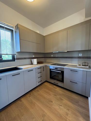 a large kitchen with white appliances and wooden floors at Aegina Horizon Stonehouse No I in Aegina