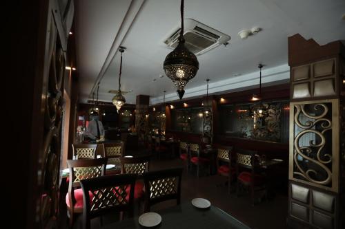 a dining room with tables and chairs and lights at The New Marrion in Bhubaneshwar
