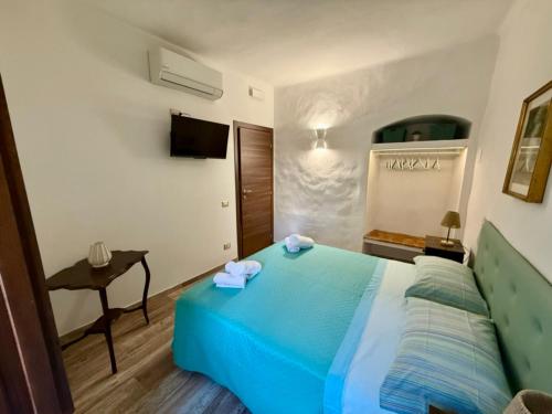 a bedroom with a blue bed and a table at CASA ALDOBRANDESCHI - Tuscan ToBe in Santa Fiora