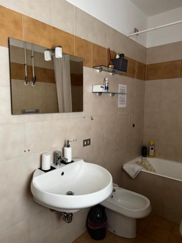 a bathroom with a sink and a toilet and a tub at Landscapesilvia 1 Aria in Menaggio