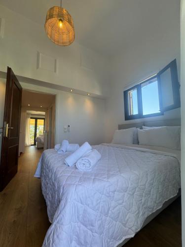 a bedroom with a large bed with white sheets at Aegina Horizon Stonehouse No I in Aegina