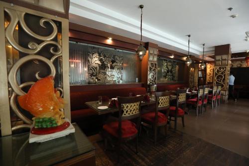 a restaurant with red chairs and tables in a room at The New Marrion in Bhubaneshwar