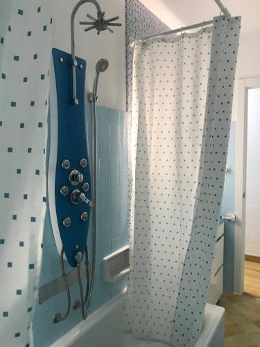 a bathroom with a shower with a blue shower curtain at Apartamento cerca de la playa in Viveiro