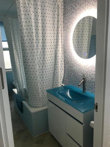 a bathroom with a blue sink and a shower at Apartamento cerca de la playa in Viveiro