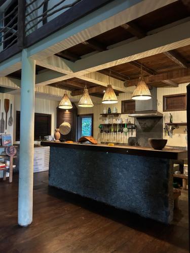 a large kitchen with a counter and pendant lights at Villa zakitoo in Sainte Marie