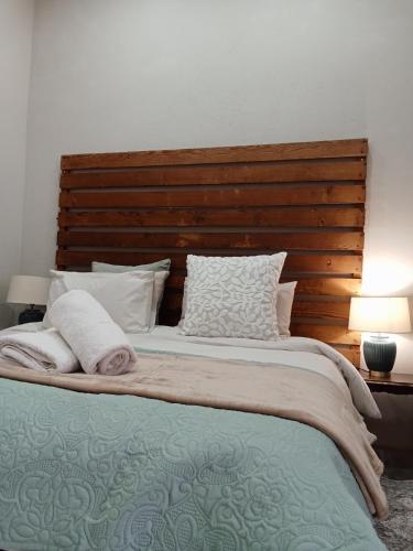 a bedroom with a large bed with a wooden headboard at Raapfontein Self-Catering and Camping in Hanover