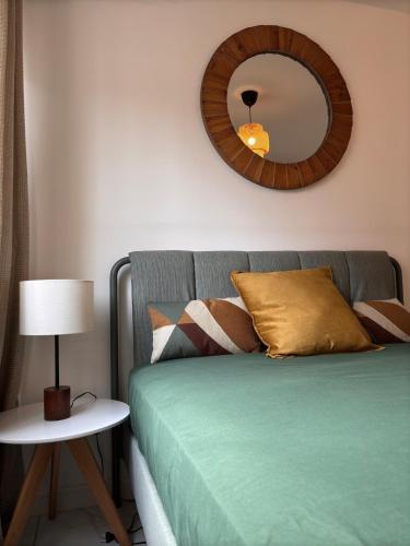 a bedroom with a bed with a mirror on the wall at L'escale direct access to train station ideal location in Annemasse