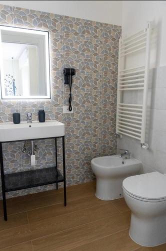 a bathroom with a sink and a toilet and a mirror at A casa di Clà in Gaeta