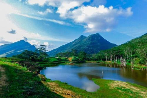 a river with a mountain in the background at Sith Meadow View Bungalow in Palapatwela