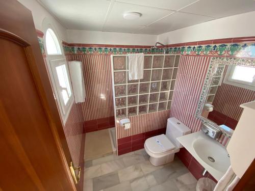 a bathroom with a toilet and a sink at Hotel La Española in Chipiona