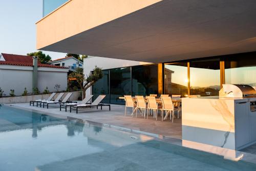 a pool with chairs and a table on a building at Beachfront Villa FUX Eternity Zdrelac Pasman Zadar in Ždrelac
