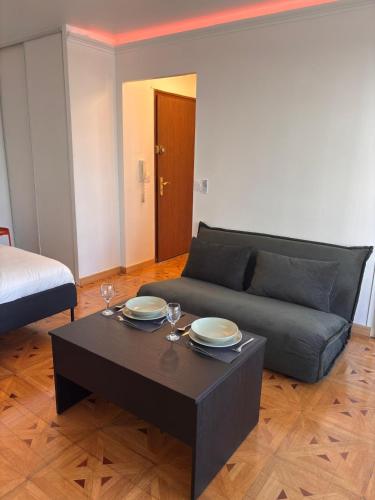 a living room with a couch and a table at La Suite - tram access and private parking in Annemasse