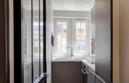 a bathroom with a sink and a window and a mirror at CASTEL SAINT CLAIR PRESTIGE - 2 Chambres - HYPER CENTRE in Deauville
