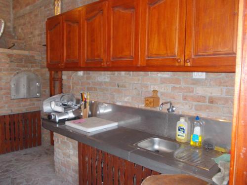a kitchen with a sink and a brick wall at Kuća za odmor "Karalic" in Ležimir