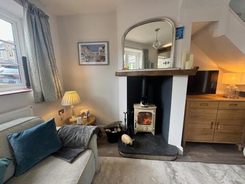 a living room with a wood stove in a living room at Sea Breeze, cottage with large woodland garden in Seaview