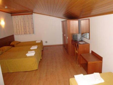 a small room with two beds and a television at Nossa Senhora do Pranto in Ferreira do Zêzere