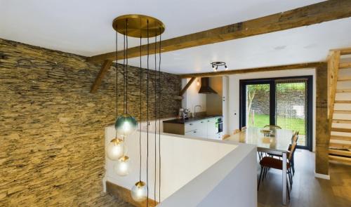 a kitchen and dining room with a stone wall at La Rocha in La Roche-en-Ardenne