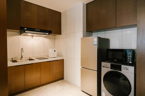 a kitchen with a refrigerator and a microwave at Wenjun Select Hotel, Changzhou in Changzhou