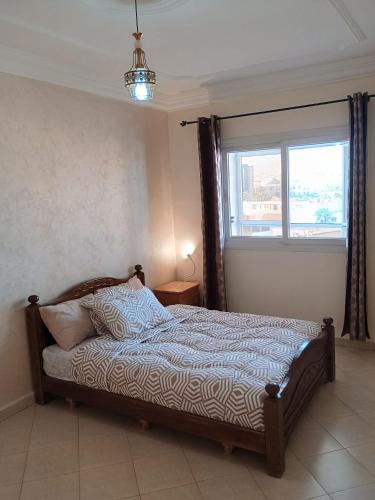 a bedroom with a bed with a window and a bed sidx sidx sidx at Appartement à usage familial in Agadir