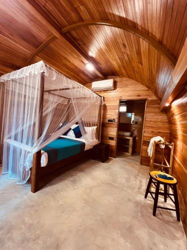 a bedroom with a bed in a wooden ceiling at Garden Oasis Rekawa in Rekawa
